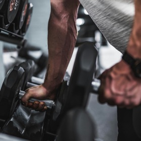 State-of-the-art amenities hands grabbing dumbbells from a weight rack