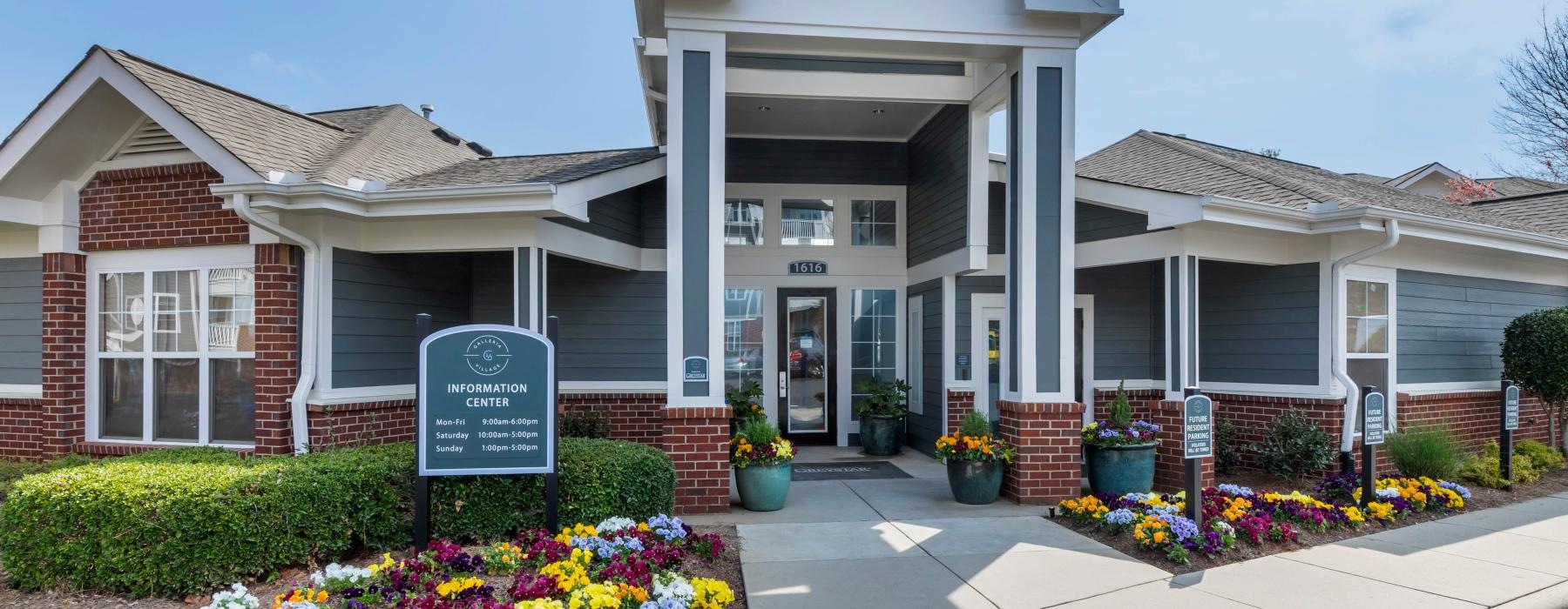 a leasing office building with a sign in front